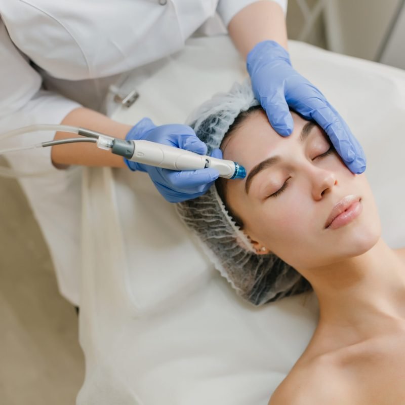 View from above rejuvenation of beautiful woman enjoying cosmetology procedures in beauty salon. Dermatology, hands in blue glows, healthcare, therapy, botox. View from above rejuvenation of beautiful woman enjoying cosmetology procedures in beauty salon. Dermatology, hands in blue glows, healthcare, therapy, botox